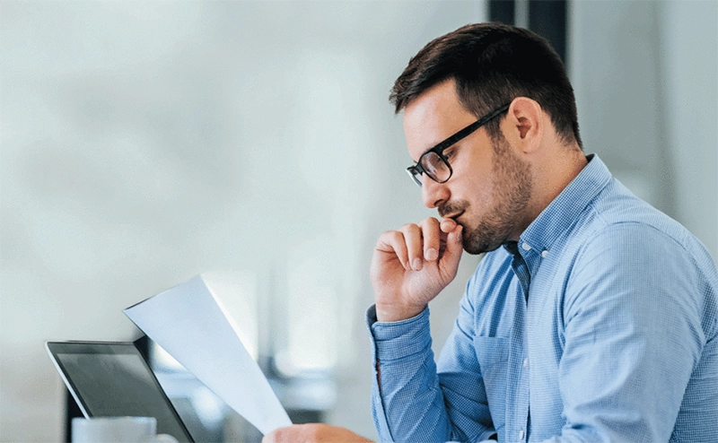 Homem analisando documentos do Catálogo de Serviços de TI