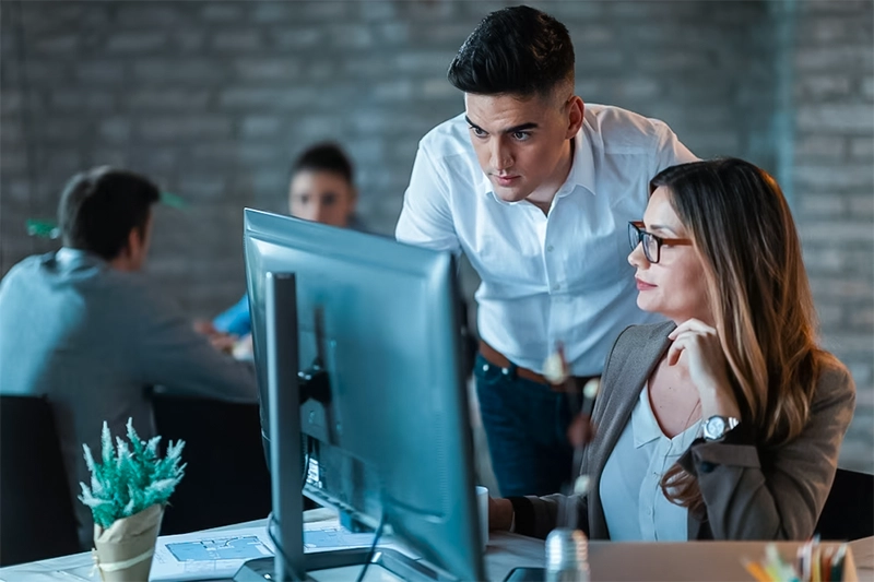 Profissional de Tecnologia da Informação ajudando funcionário