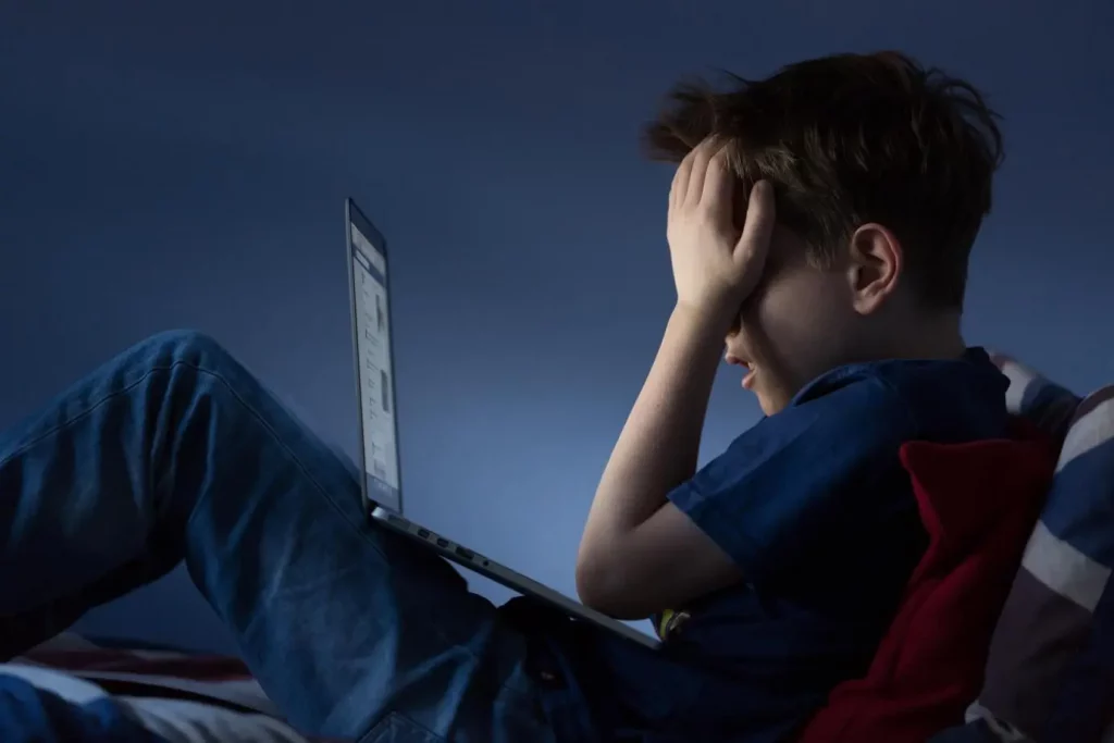 Criança chorando em frente do computador