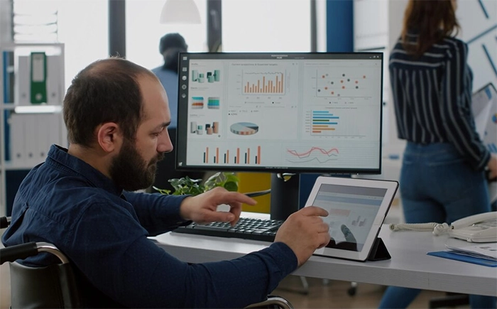 homem na frente do computador com números e gráficos