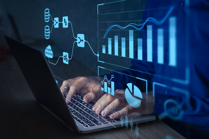 tela com gráficos e pessoa digitando no computador