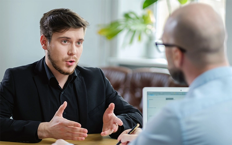 Dois homens conversando em reunião de negócios.