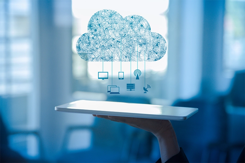 Ao fundo, pessoa utilizando computador, em foco, um desenho de nuvem.