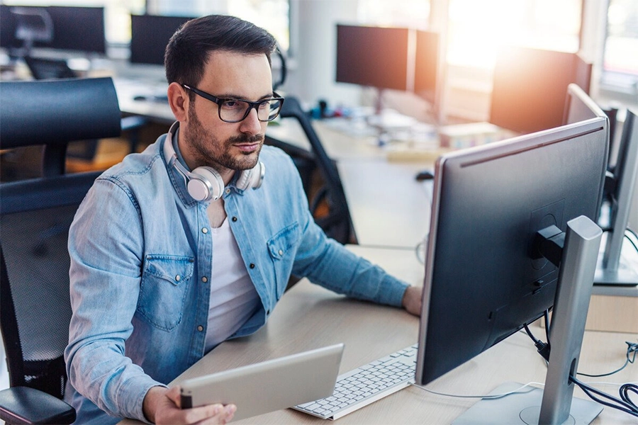 Homem em frente ao computador resolvendo problemas de segurança da informação