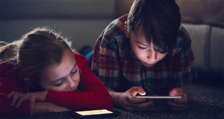 Crianças utilizando tablet e celular